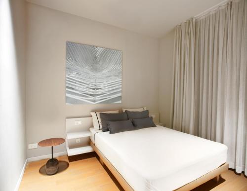 a white bedroom with a bed and a table at Trogir SkyView Suites in Trogir