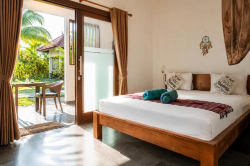 a bedroom with a bed with a stuffed animal on it at Bali Mynah Villas, Balangan Beach in Jimbaran