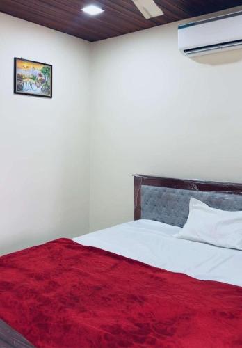 a bedroom with a bed with a red blanket at Dove Convention in Machilīpatnam
