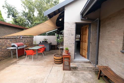a patio with a table and chairs and a building at Bucklebury inn in Centurion