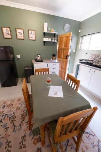 a dining room with a table and chairs in a kitchen at Bucklebury inn in Centurion