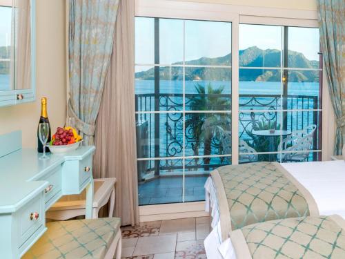 a bedroom with a bed and a large window at Kahveci Alibey Hotel in Marmaris