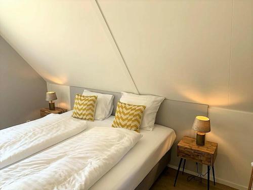 a room with two beds and a table with a lamp at Het Belegh van Groll 5-persoons in Lievelde