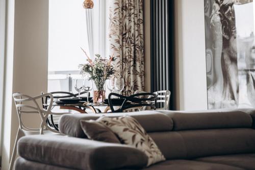 a dining room table with a couch and a table and chairs at Apartament Złote Noce in Augustów