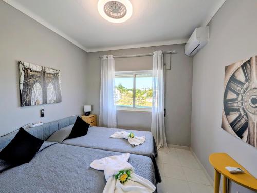 a bedroom with two beds and a window at 4º5 Edificio Mar - Casas & Papeis in Armação de Pêra