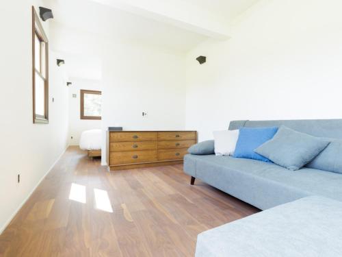 a living room with a blue couch and a dresser at Locanda Furanora in Furano