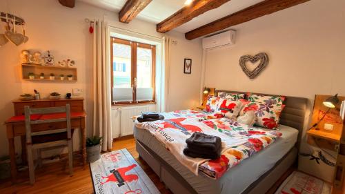 a bedroom with a bed and a desk and a window at GITE LE COQ ROUGE in Eguisheim