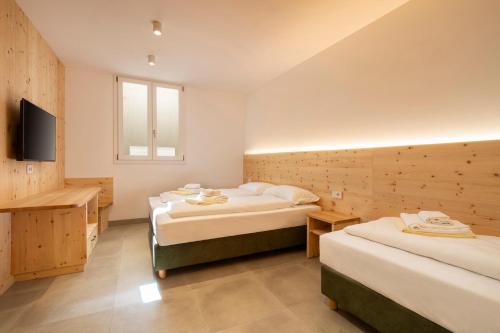 a hotel room with two beds and a television at NNV Pool Villa Lazise in Lazise