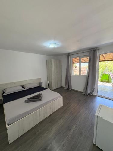ein Schlafzimmer mit einem großen Bett und Holzböden in der Unterkunft Vila Aron in Tuzla