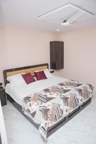 a bedroom with a large bed with red pillows at V Rooms in Pendurti