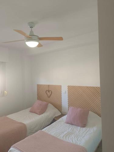 a room with two beds and a ceiling fan at Marina Tavernes in Tavernes de Valldigna