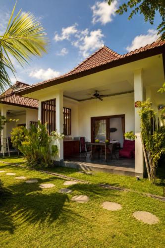 a villa with a garden and a house at Bali Mynah Villas, Balangan Beach in Jimbaran