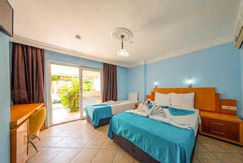 a hotel room with two beds and a desk at Side Temple Hotel in Side
