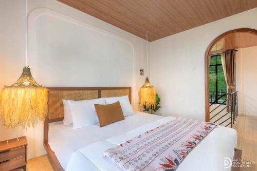 a bedroom with a white bed and a balcony at Diamond Cabin 3 in Diyeng