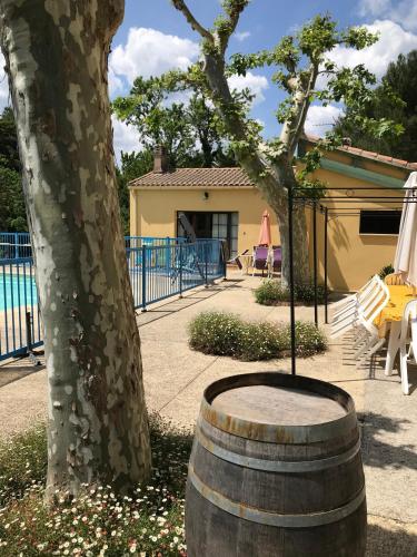 a barrel sitting next to a tree next to a house at Philippe in Beaurecueil