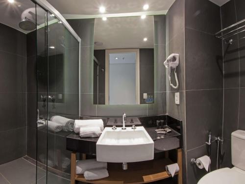 a bathroom with a sink and a mirror and a toilet at ibis Styles Boa Vista in Boa Vista