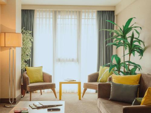 a living room with a couch and chairs and a plant at ibis Styles Istanbul Bomonti in Istanbul