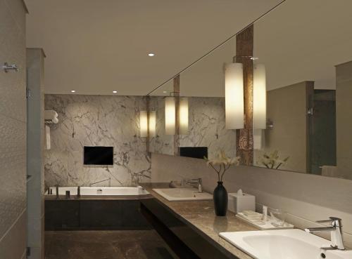 a bathroom with two sinks and a large mirror at Hilton Chennai in Chennai