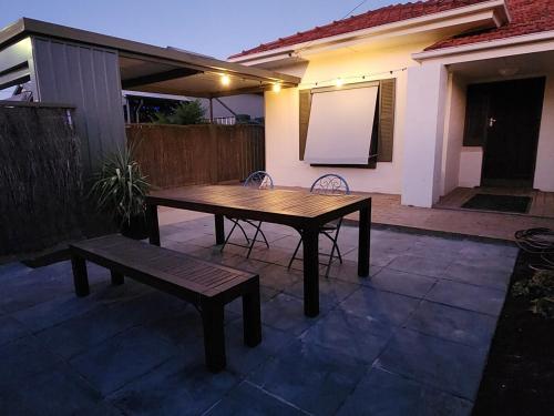 a wooden table and a bench in front of a house at Entire Unit in Brooklyn Park in West Richmond
