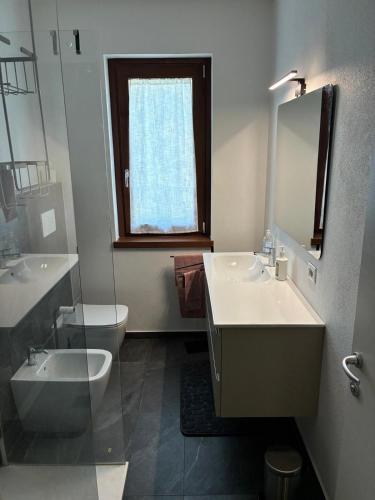 a bathroom with a sink and a toilet and a mirror at Casa RIGPA in Bellagio