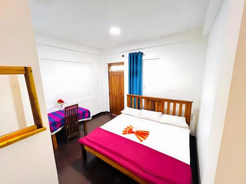 a bedroom with a bed and a table with a chair at Mandaram Nuwara Sunset Villa in Nuwara Eliya