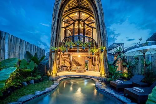 a large building with a pool in front of it at The Queen Bamboo Ubud in Ubud