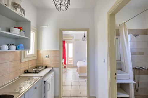 a white kitchen with a sink and a mirror at Marili Apartments Studios in Parasporos