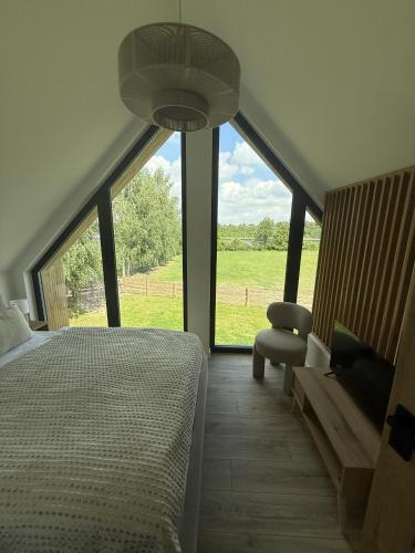 a bedroom with a bed and a view of a field at Winnica Osada Moszczonne in Moszczonne