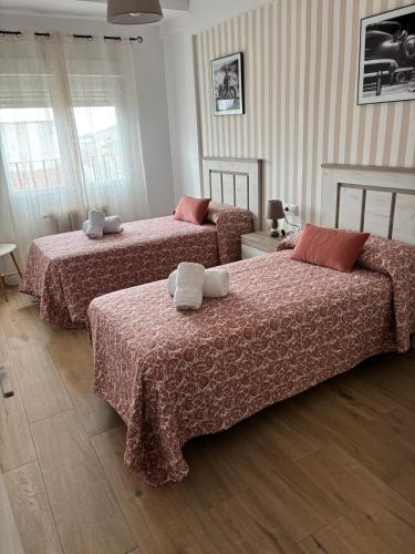 two beds in a hotel room with red sheets at VUT TRINIDAD 3 dormitorio in La Guardia