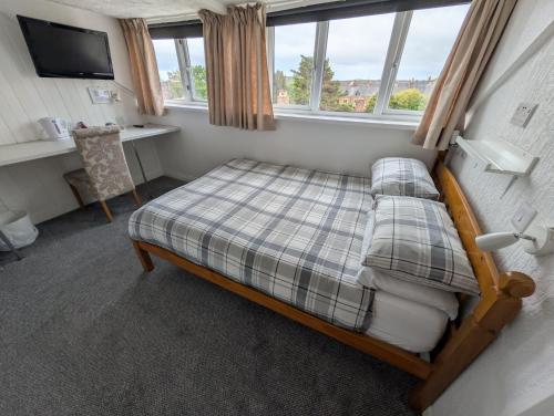 a small bedroom with a bed and a desk at Annie's Accommodation in South Shields