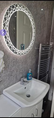 a bathroom with a white sink and a mirror at Hillend Self-Catering in Portree