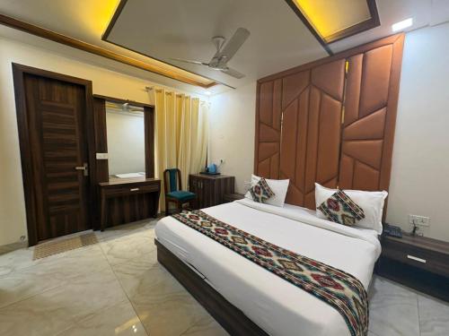 a bedroom with a bed and a desk and a door at The Crown Hotel Agra near Taj Mahal in Agra