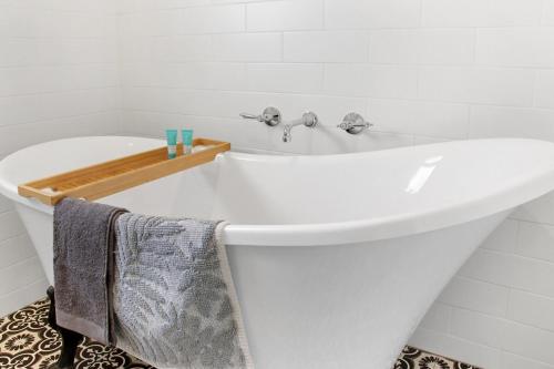 a white bath tub in a white bathroom at Retro Retreat in Highton