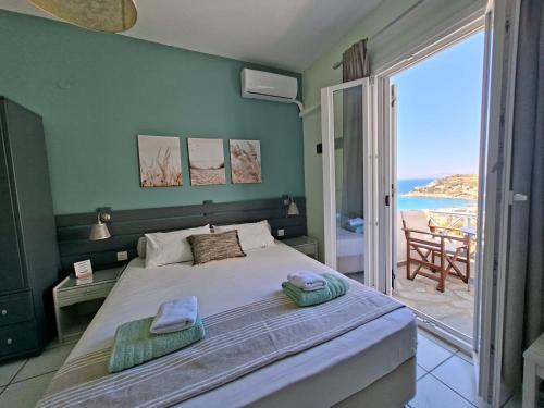 a bedroom with a bed with a view of the ocean at Kini Bay in Kini