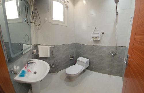 a bathroom with a toilet and a sink at المهيدب 3 للشقق المخدومة - اقتصادى in Buraydah