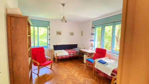 a living room with red chairs and a table at Park Apartman in Sály