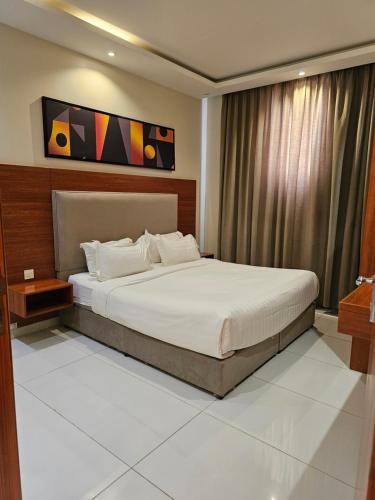 a bedroom with a large bed in a room at المهيدب 3 للشقق المخدومة - اقتصادى in Buraydah