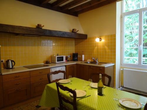 une cuisine avec une table et un tissu de table vert dans l'établissement Maison Gille, à Nuits-Saint-Georges