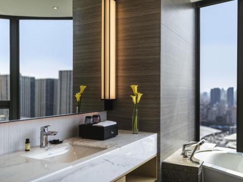 a bathroom with a sink and a large mirror at Pullman Fuzhou Tahoe in Fuzhou