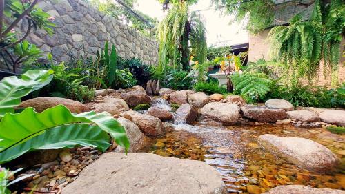 a garden with a stream of water and rocks at SHAN Villas Sukhumvit ฌานวิลล่า สุขุมวิท in Bangkok