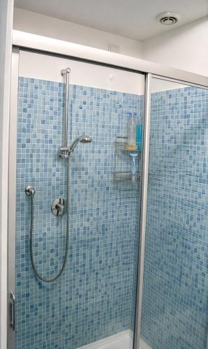 a bathroom with a shower with blue tiled walls at BellaVista - Vallecrosia in Vallecrosia