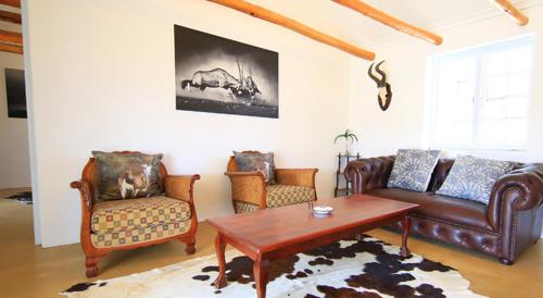 a living room with leather furniture and a coffee table at Arnion - Nature Retreat in Clanwilliam