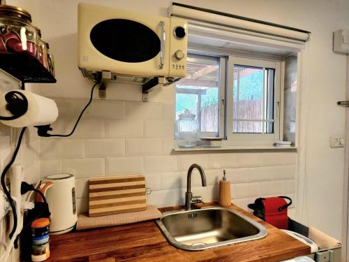 a kitchen with a sink and a microwave at וילה נחל טביה in Arad