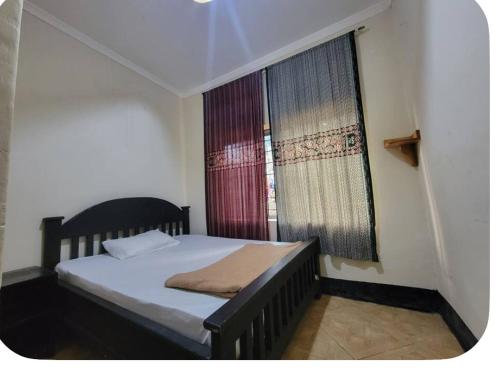 a small bedroom with a bed and a window at Iringa Hillside backpackers in Iringa