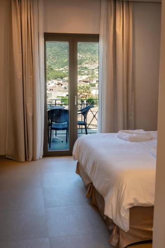 a bedroom with a bed and a view of a balcony at Filakas in Syvota