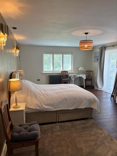 a bedroom with a large bed with a table and chairs at Boycott House in Shalstone