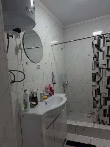 a white bathroom with a shower and a sink at Friendly House in Bokonbayevo