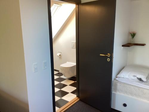 a bathroom with a door leading to a bathroom with a toilet at Enghaven Bed & Kitchen in Ansager