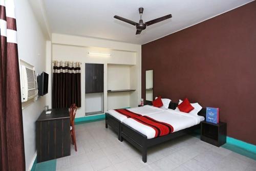 a bedroom with a large bed with red pillows at Hotel Penguin International in Kolkata