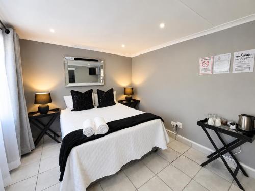 a bedroom with a large bed with black pillows at Zhantique Guest House 2- Unit 1 in Boksburg